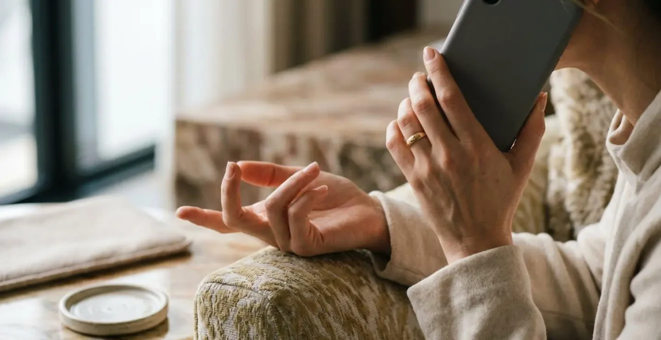 Mains élégantes tenant un téléphone lors d'une réservation dans un cadre raffiné