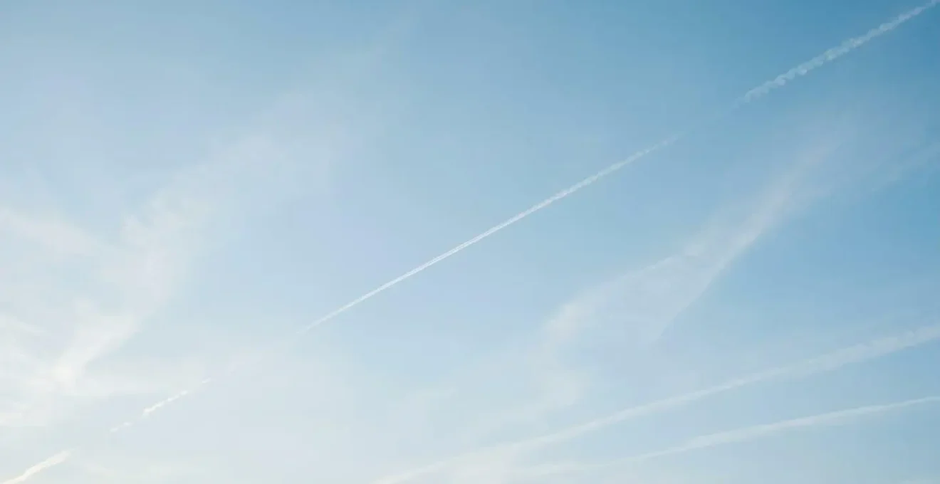 Vue minimaliste et environnementale d'un ciel dégagé avec traînées de condensation d'avion, évoquant la connectivité et les transmissions de données en altitude