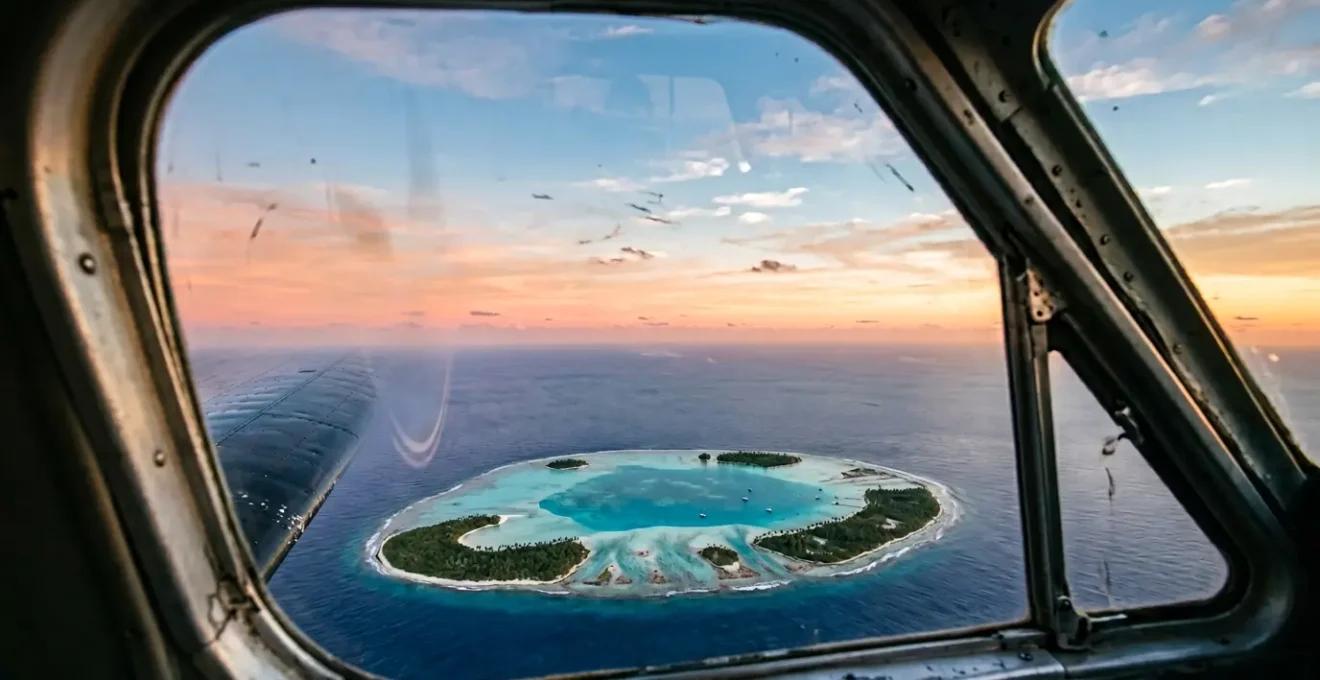 Vue aérienne spectaculaire d'un atoll du Pacifique au lever du soleil depuis un hydravion en approche